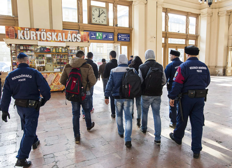 Intézkedő rendőrök elviszik a Keleti pályaudvarról a Győrön és Bécsen át Münchenbe tartó Kálmán Imre Euronigth járatról leszállított menekülteket (Fotó: MTI)