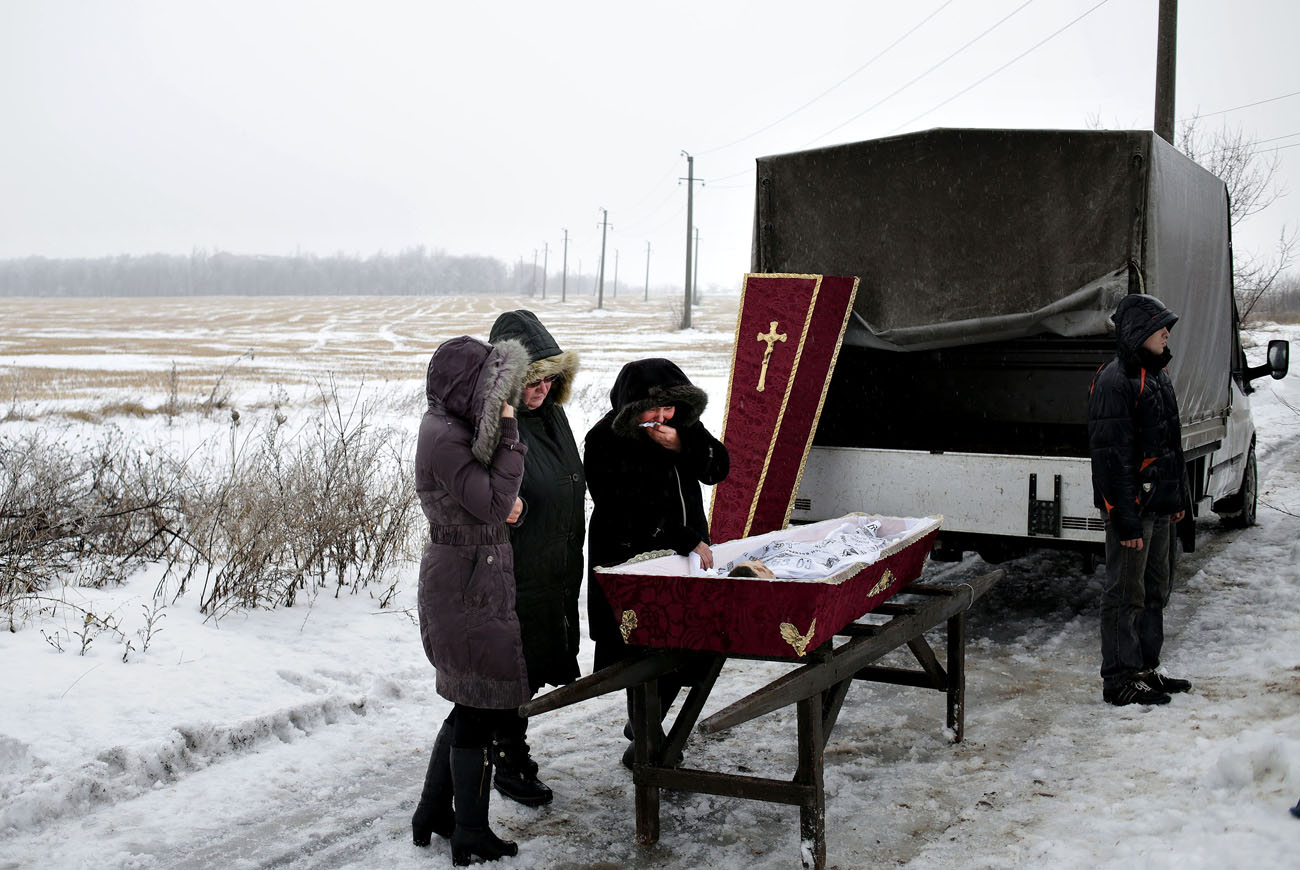 Egy 11 évesen elhunyt fiút temetnek a rokonai Debalceve mellett. A fiú egy légi csapás során szerzett halálos sérülést. (Fotó: Anastasia Vlasova) 