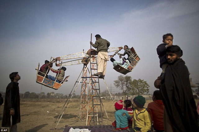 Megdöbbentő fotók: így játszanak a gyerekek Pakisztán nyomornegyedeinek vidámparkjaiban