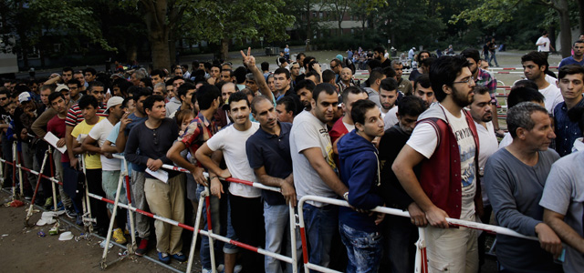 Migránsok sorakoznak egy befogadóközpont előtt, hogy nyilvántartásba vegyék őket 2015. szeptember 1-jén. (MTI/AP/Markus Schreiber)