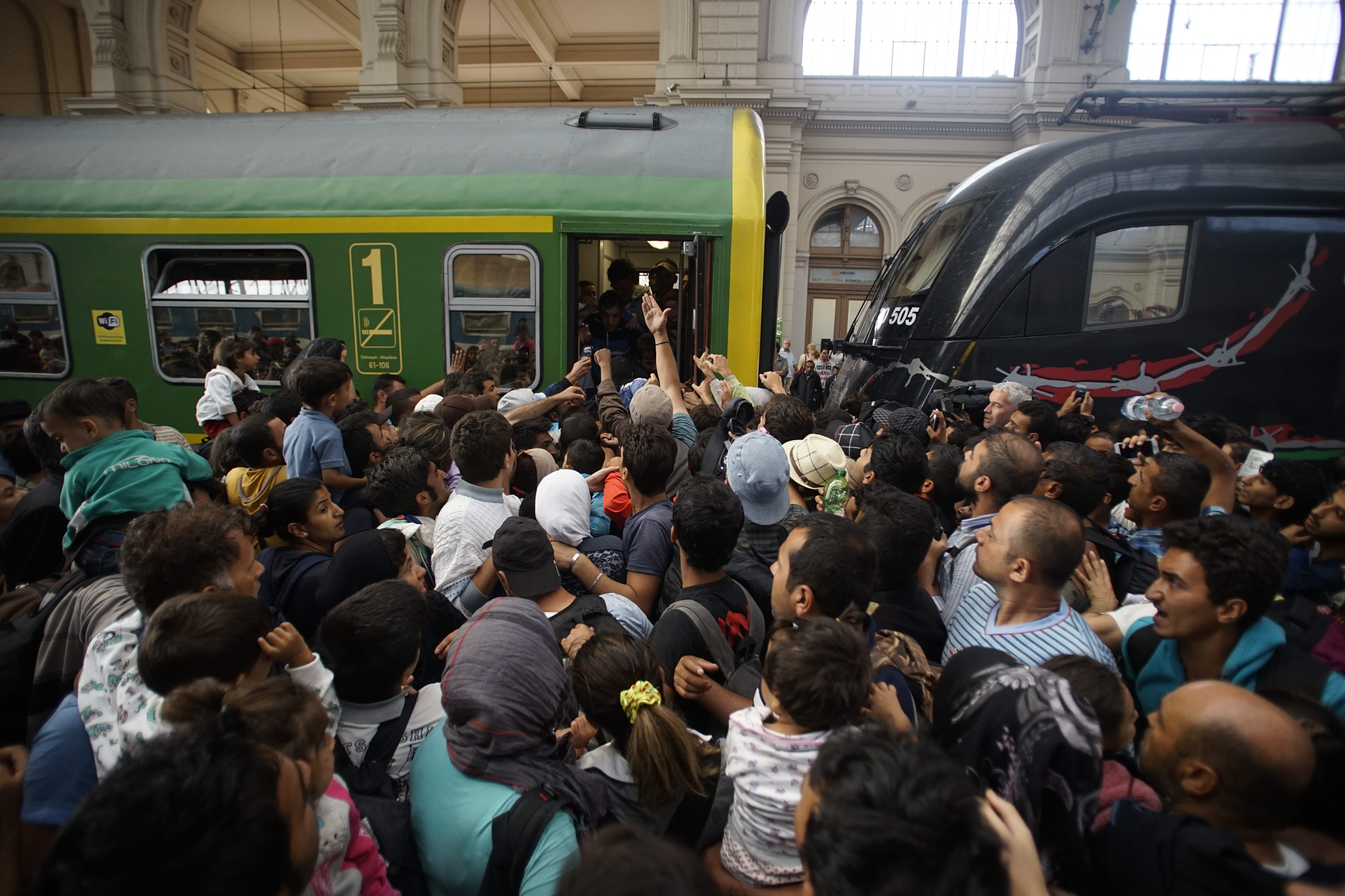 Menekültek próbálnak felszállni a Keleti pályaudvaron a Győrbe tartó vonatra - Fotó: MTI)