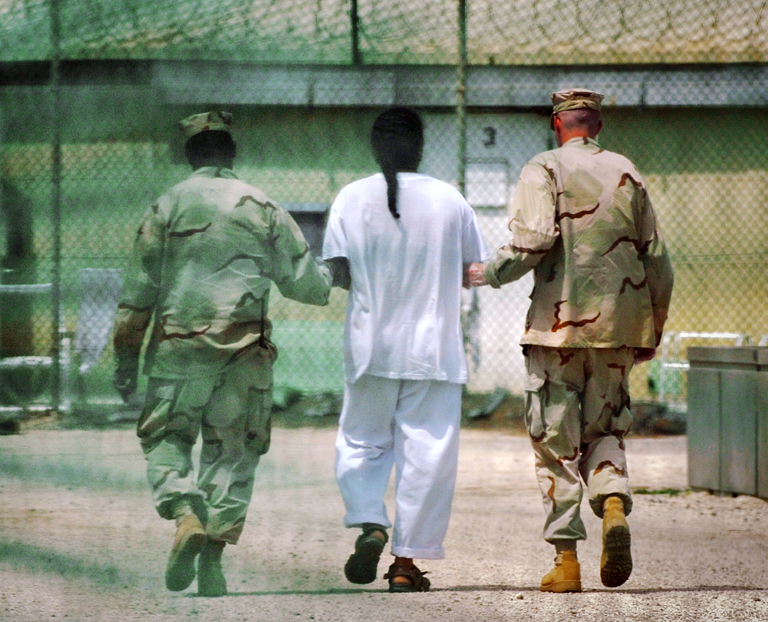 Egy fogvatartottat kísérnek a Camp Delta fogolytáborban Guantanamón