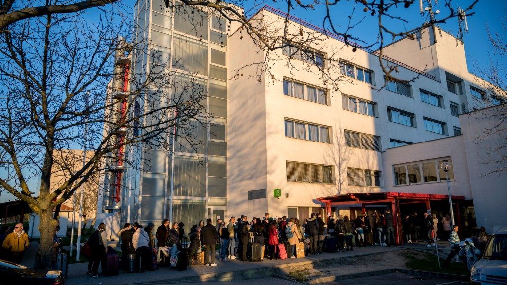 Hallgatók várakoznak a kiköltözésre a Pécsi Tudományegyetem Szalay László Kollégium épülete előtt (Fotó: MTI/Sóki Tamás)