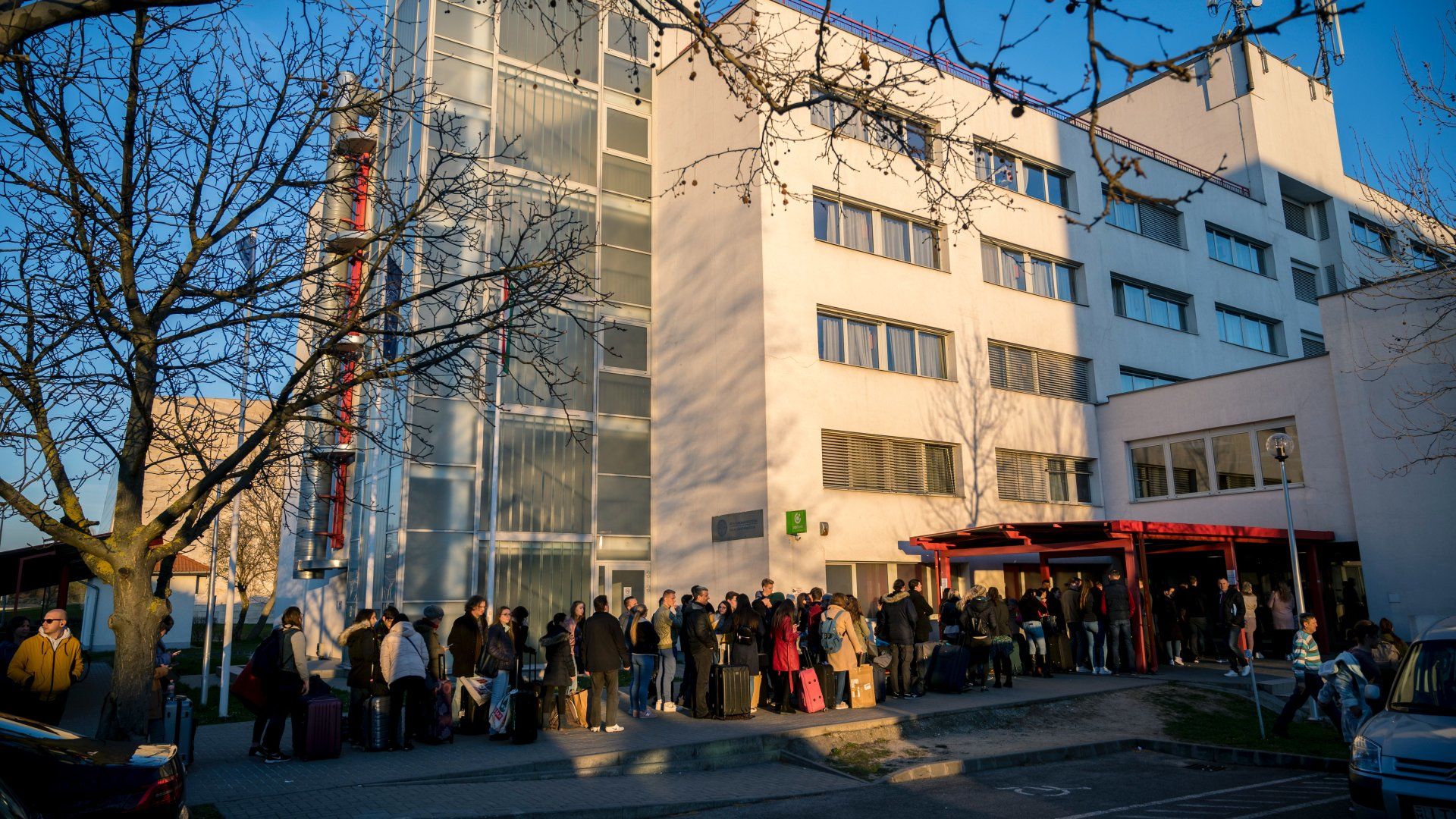 Hallgatók várakoznak a kiköltözésre a Pécsi Tudományegyetem Szalay László Kollégium épülete előtt Pécsen 2020. március 16-án (Fotó: MTI/Sóki Tamás)