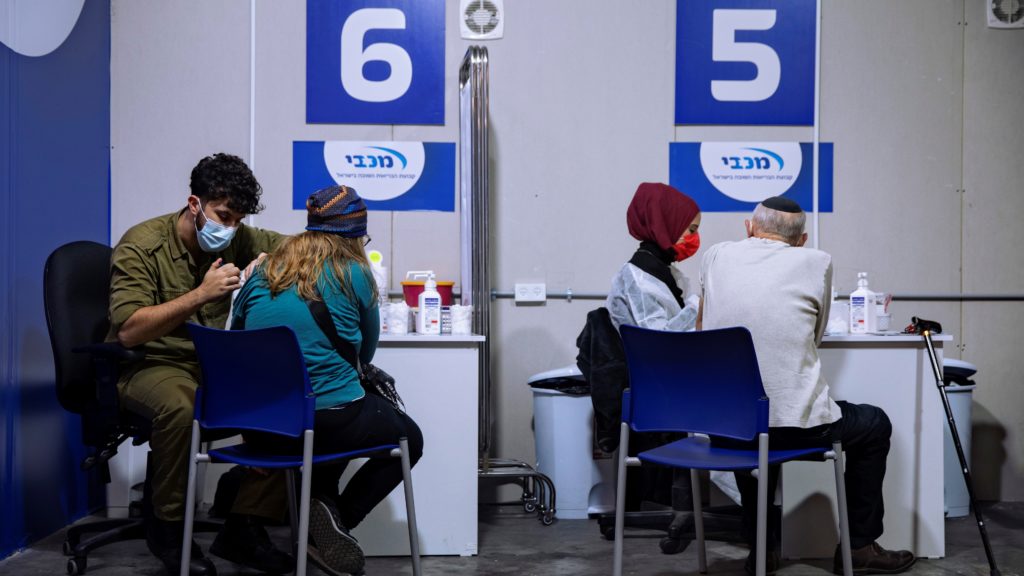 Izraelieket oltanak a Pfizer-BioNTech cégek koronavírus elleni vakcinájával egy bevásárlóközpont parkolójában, Givatayimban 2021. január 20-án. 