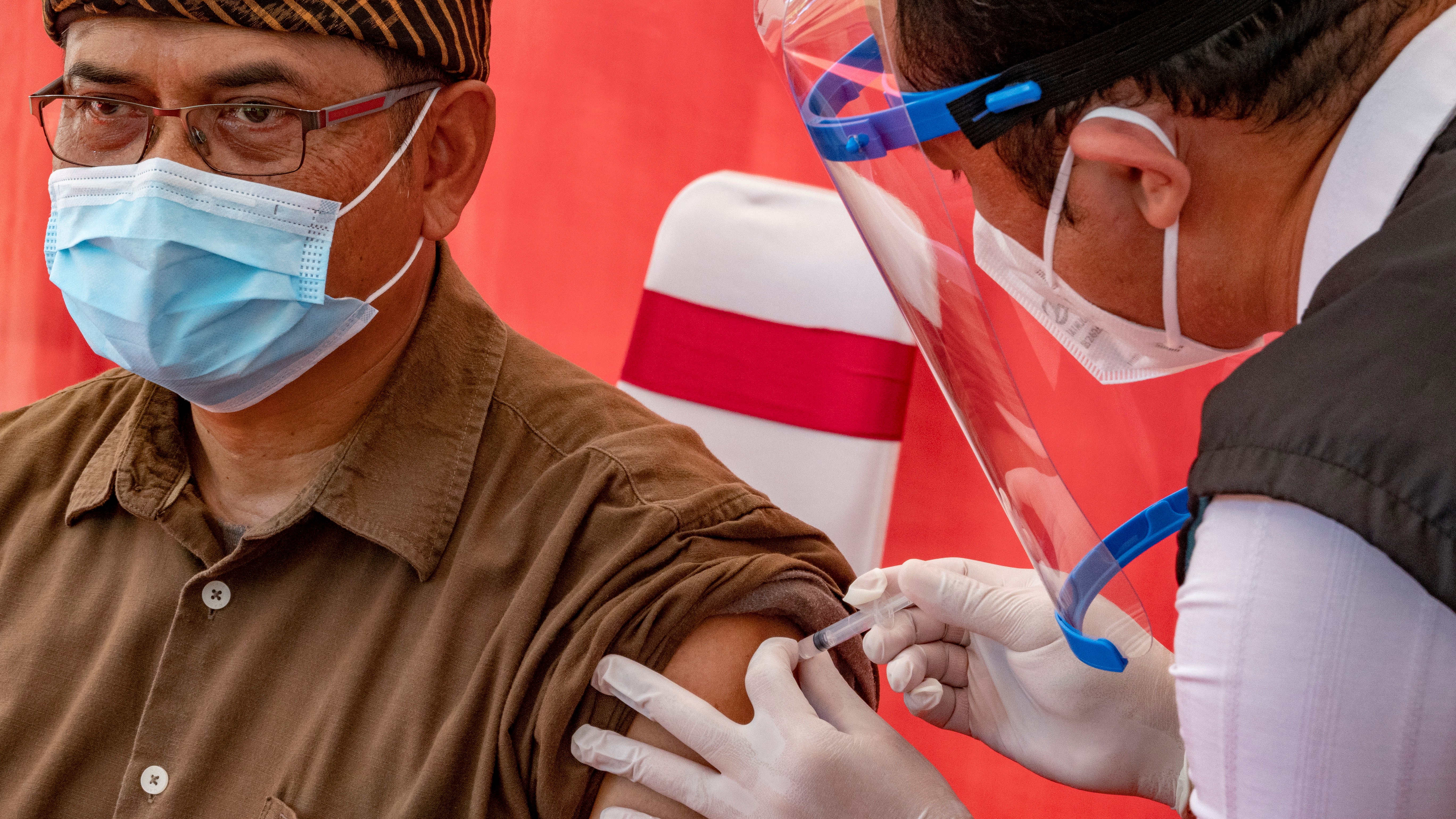Az új koronavírus ellen oltanak be egy egészségügyi dolgozót a Bali szigetén fekvő Denpasarban 2021. január 14-én.