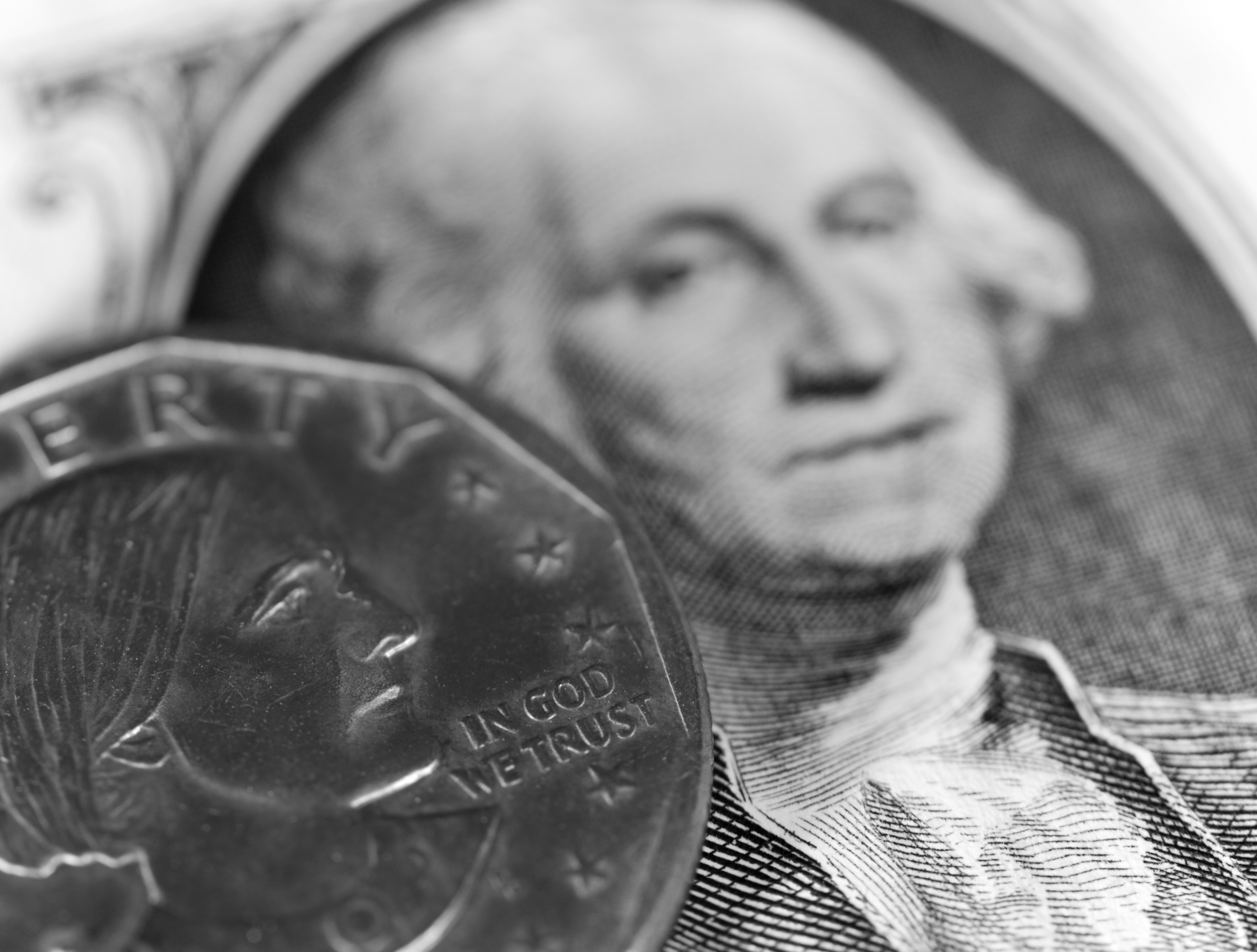 Susan B. Anthony dollar coin resting next to image of George Washington on a dollar bill.