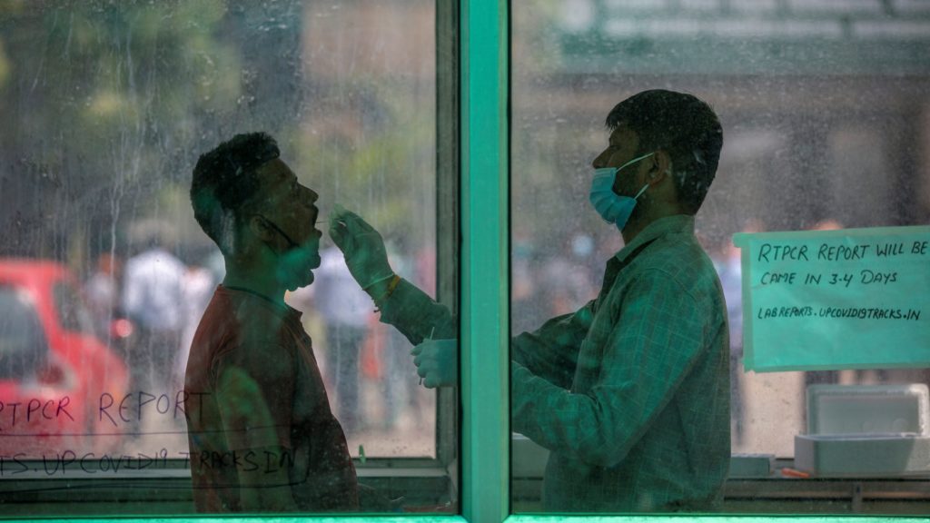 Vizsgálati mintát vesznek koronavírus-tesztre egy férfitől az Újdelhi szomszédságában fekvő Noidában 2021. április 15-én. 