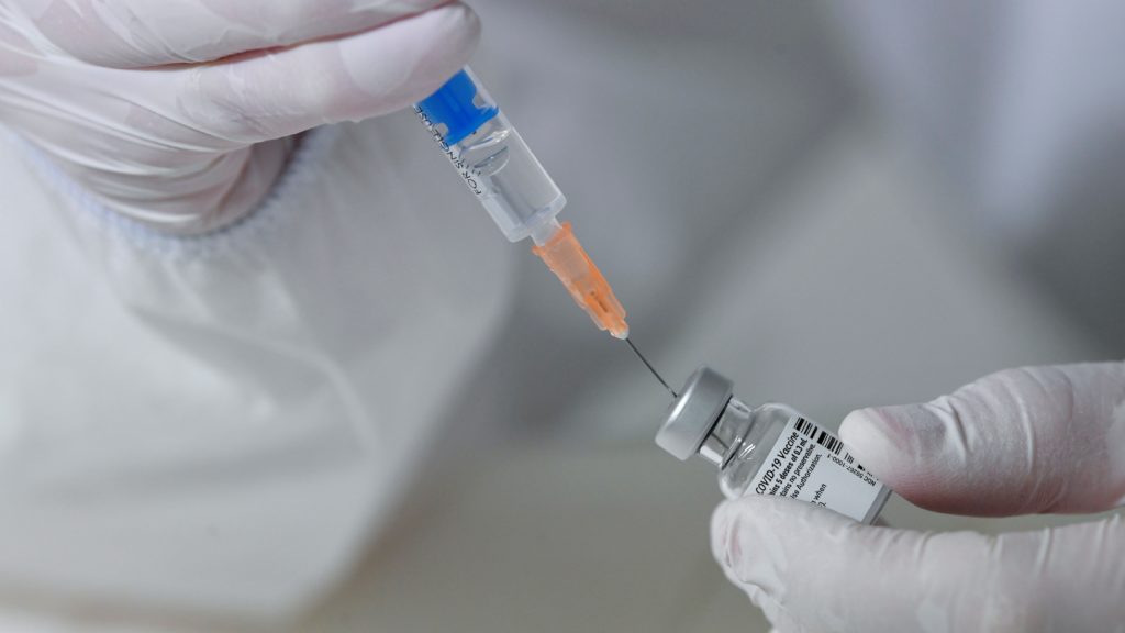 A Debreceni Egyetem Kenézy Gyula Egyetemi Kórház Infektológiai Intézetének szakgyógyszerésze a koronavírus elleni oltóanyaggal az intézet oltópontján 2020. december 27-én.