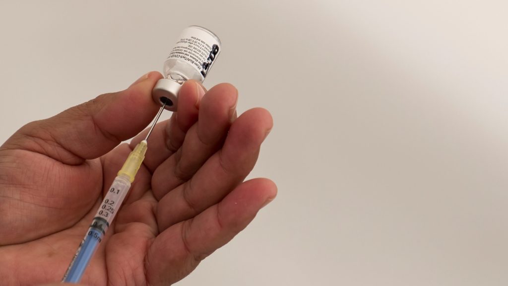A Pfizer és a BioNTech gyógyszeripari vállalatok koronavírus elleni vakcinájának beadására készül egy egészségügyi dolgozó. (