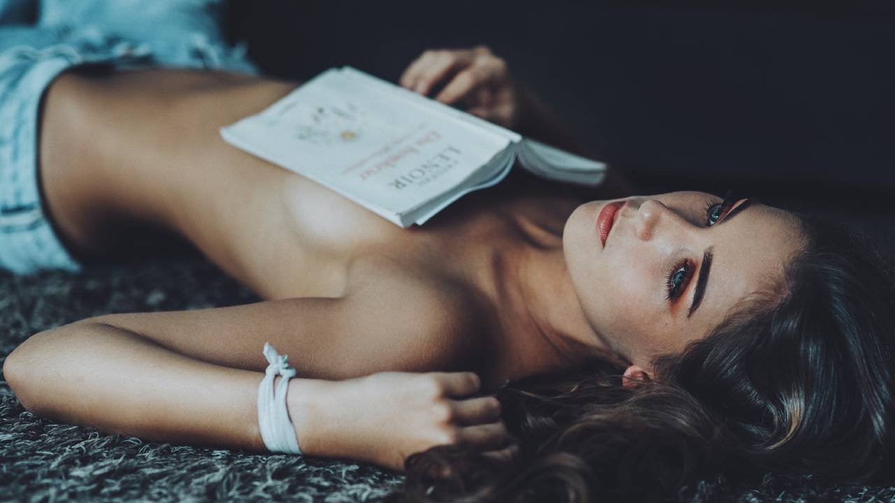 szexi nő könyvvel fekszik