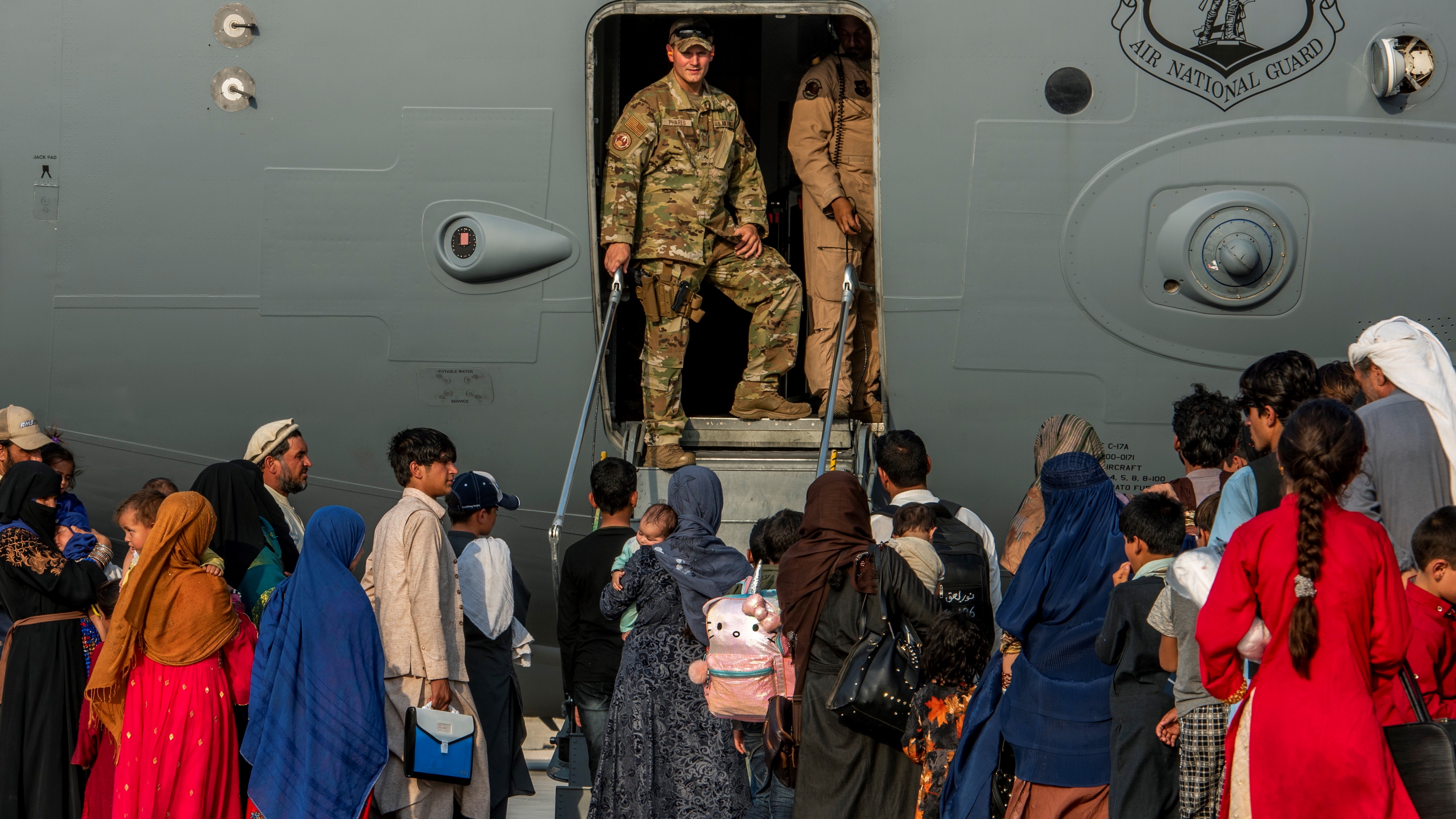 Az amerikai központi parancsnokság által közreadott képen Afganisztánból kimenekített emberek készülnek beszállni egy C-17 Globemaster III amerikai katonai teherszállító repülőgépbe a katari el-Udeid légi támaszponton 2021. augusztus 22-én. Az Egyesült Államok és szövetségesei légi úton menekítik ki a külföldi állampolgárokat és a velük együttműködő afgánokat, miután az iszlamista tálibok elfoglalták Afganisztán csaknem egészét.MTI/EPA/Amerikai központi parancsnokság/Kylie Barrow