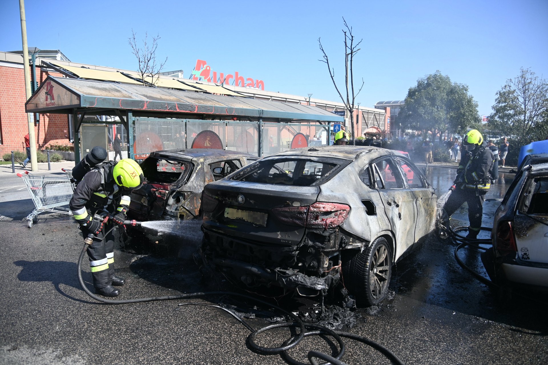 Tűzoltók egy soroksári bevásárlóközpont parkolójában, ahol kigyulladt öt személygépkocsi 2021. szeptember 6-án (Fotó: MTI/Mihádák Zoltán)