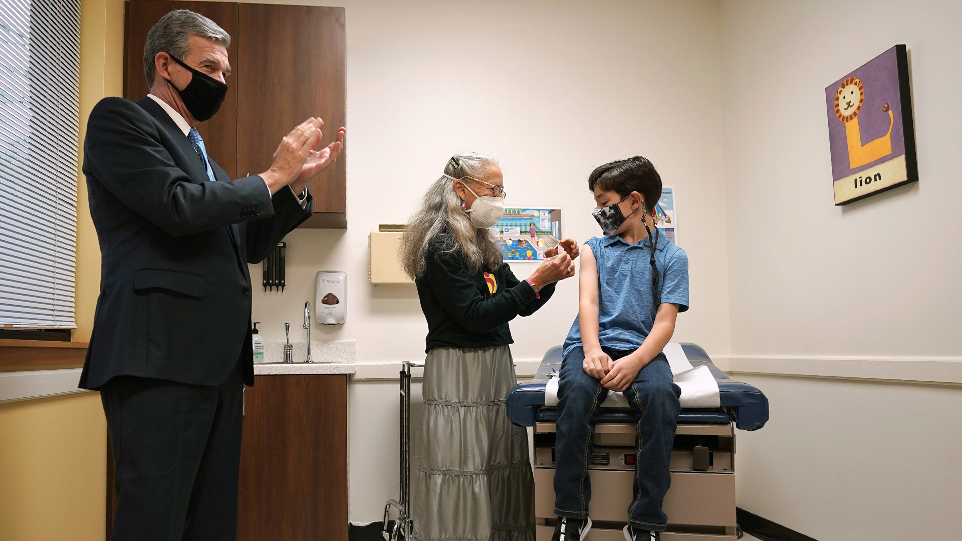 Roy Cooper kormányzó (b) gratulál a nyolcéves Daniel McCullocknak, miután megkapta az első adag koronavírus elleni védőoltását az Észak-Karolina állambeli Chapel Hillben 2021. november 4-én. / Fotó: MTI/AP/Gerry Broome