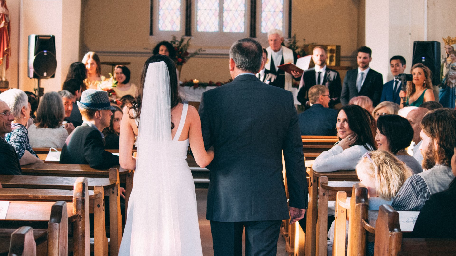 Templomi esküvőn oltárhoz kísérik a menyasszonyt