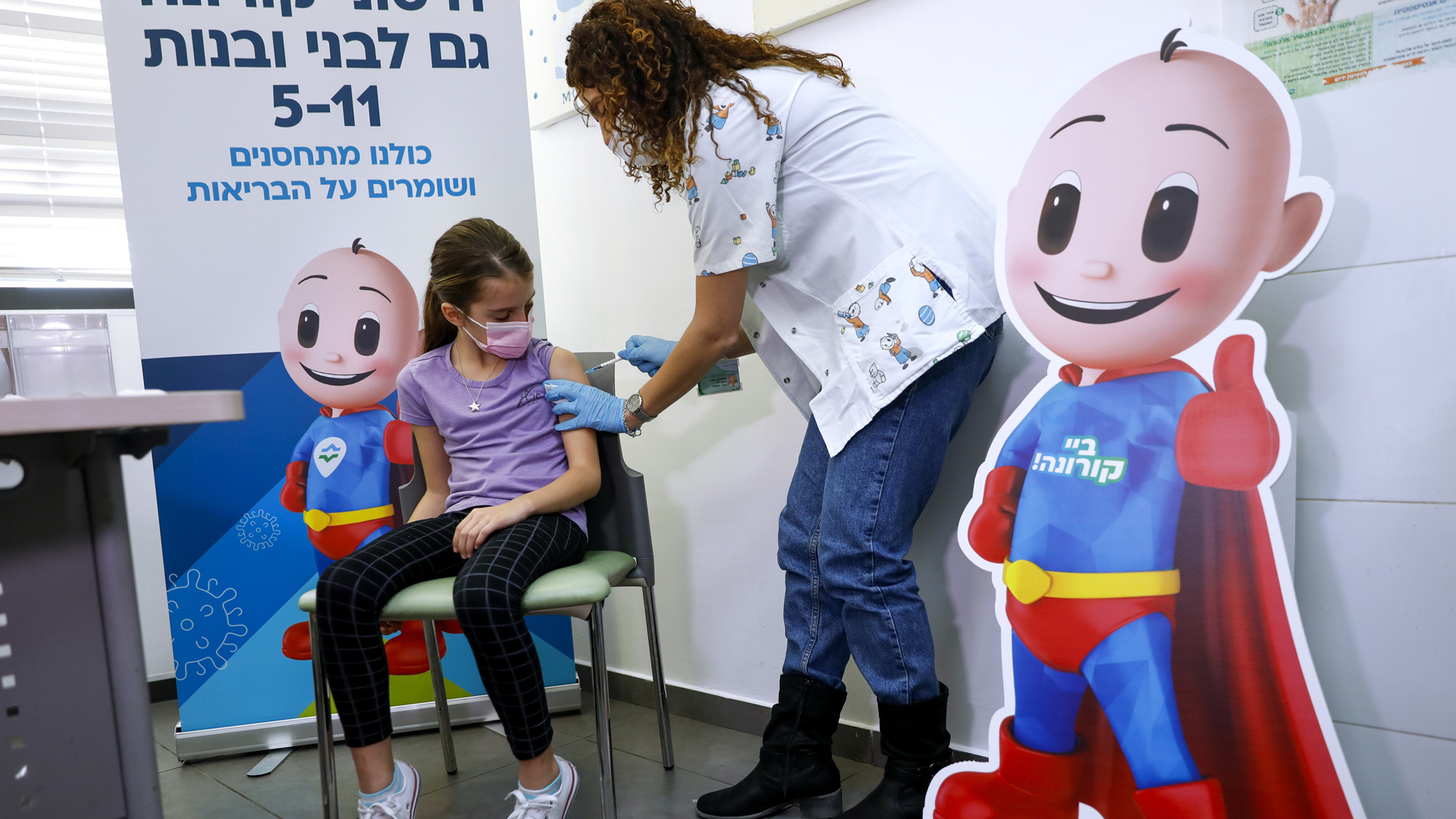 Egy kilencéves lány megkapja az első adag koronavírus elleni védőoltását Tel-Avivban 2021. november 23-án. Izraelben megkezdődött az 5 és 11 éves kor közötti gyermekek oltása. MTI/AP/Oded Balilty