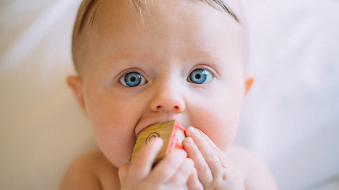 Kockát szájába tevő kisbaba