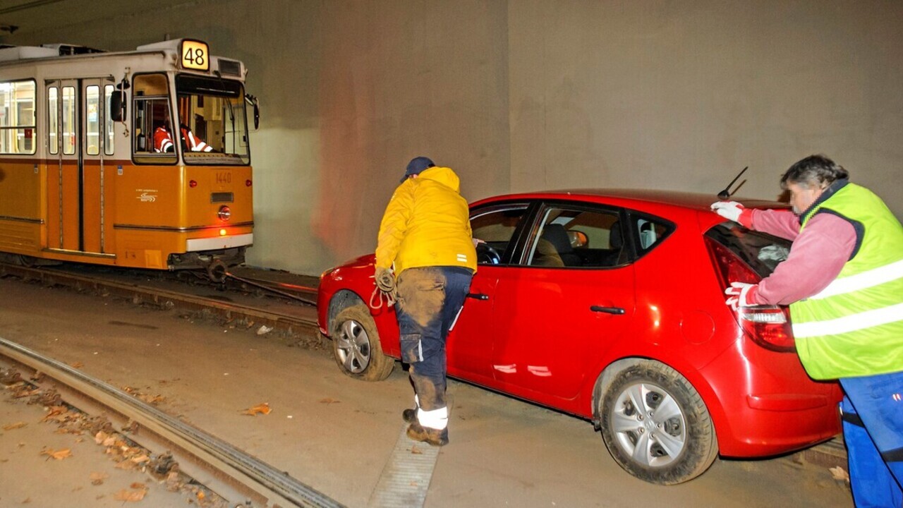 Villamos vontatta le a sínekről az autót (Fotó: MTI, Lakatos Péter)
