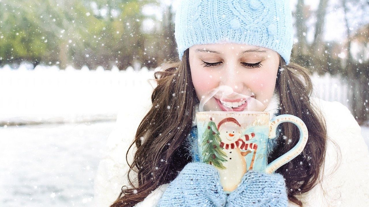 Lány télen sapkában, teával