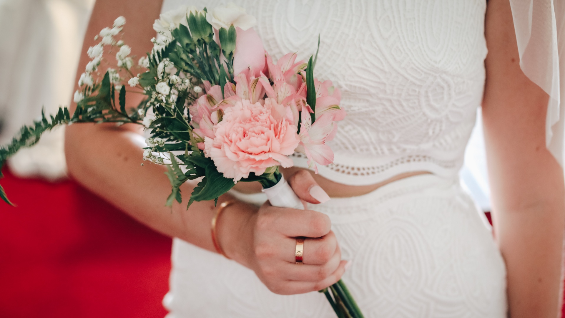 Virágcsokrot tart a kezében a menyasszony az esküvőn