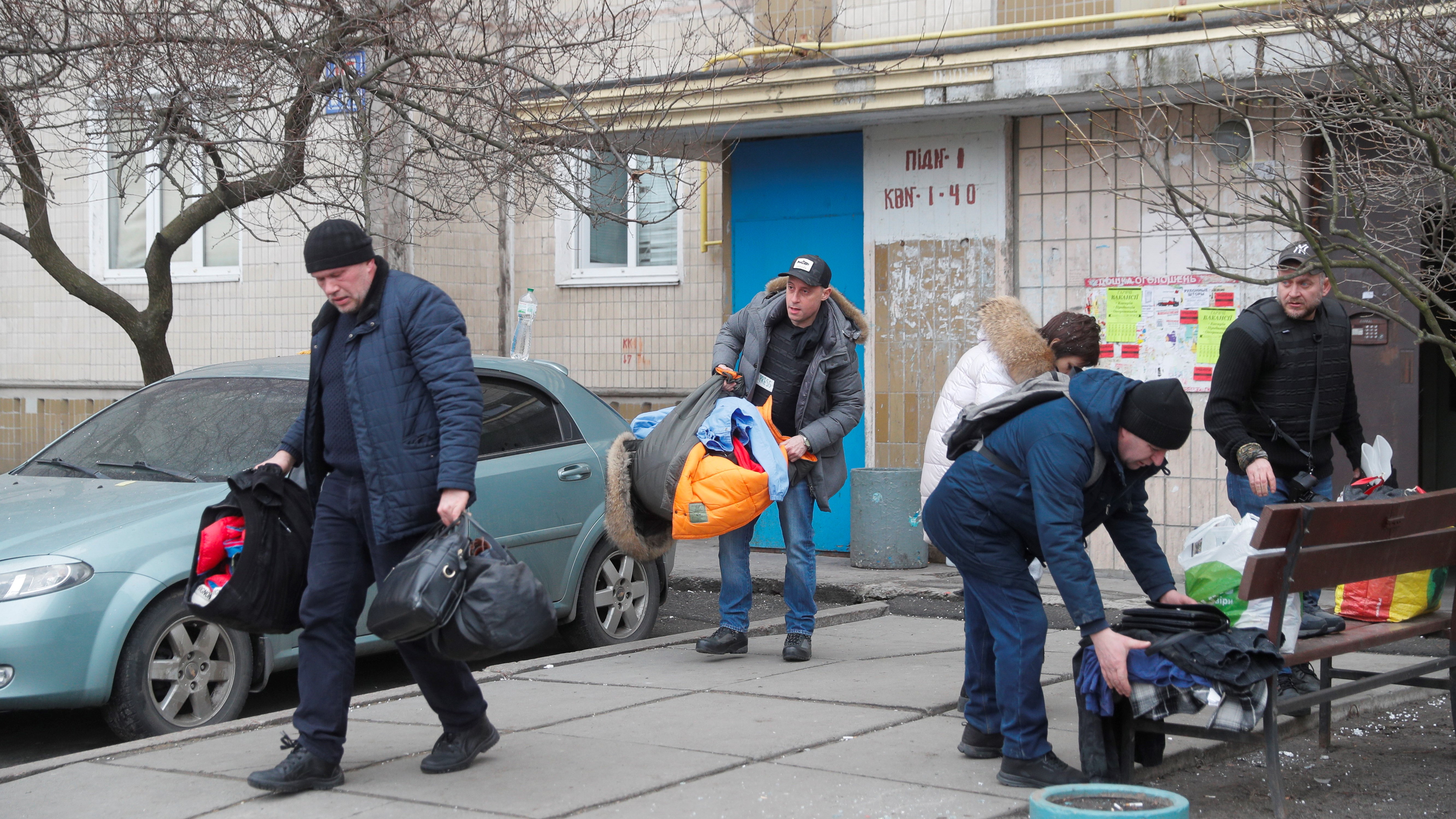 Táskákban viszik a számukra fontos dolgokat egy ház lakói Kijevben 2022. február 25-én. (Fotó: MTI/EPA/Szerhij Dolzsenko)