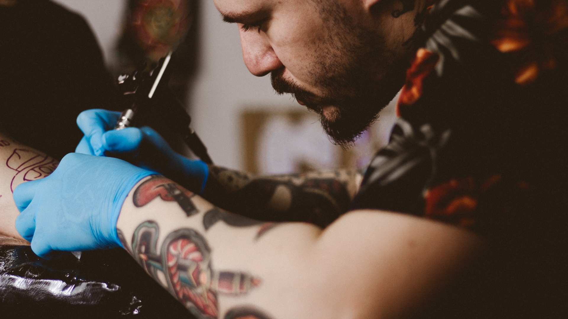 Egy férfi tetoválást készít egy nőnek
