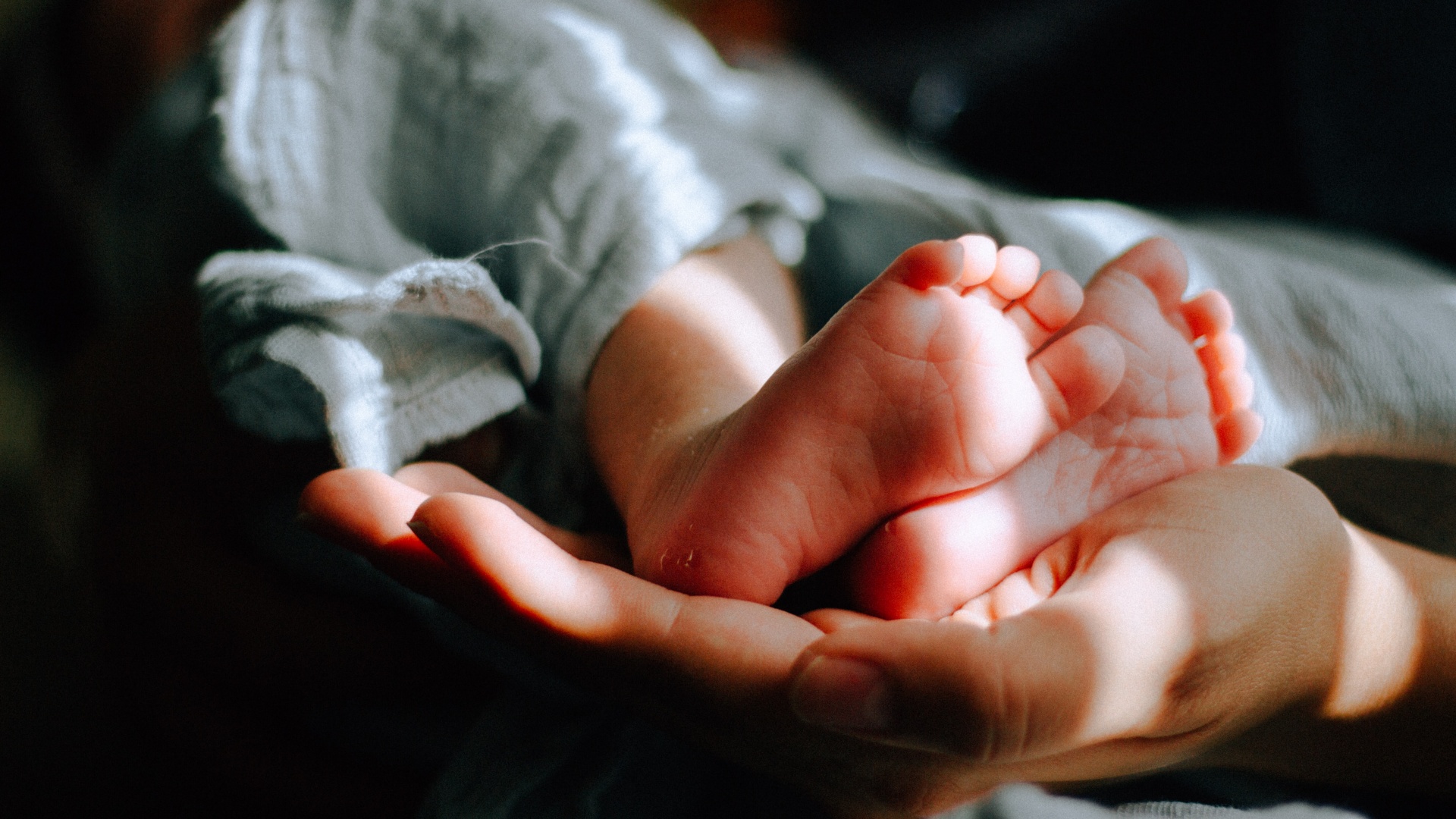 Egy újszülött talpai anyja kezében