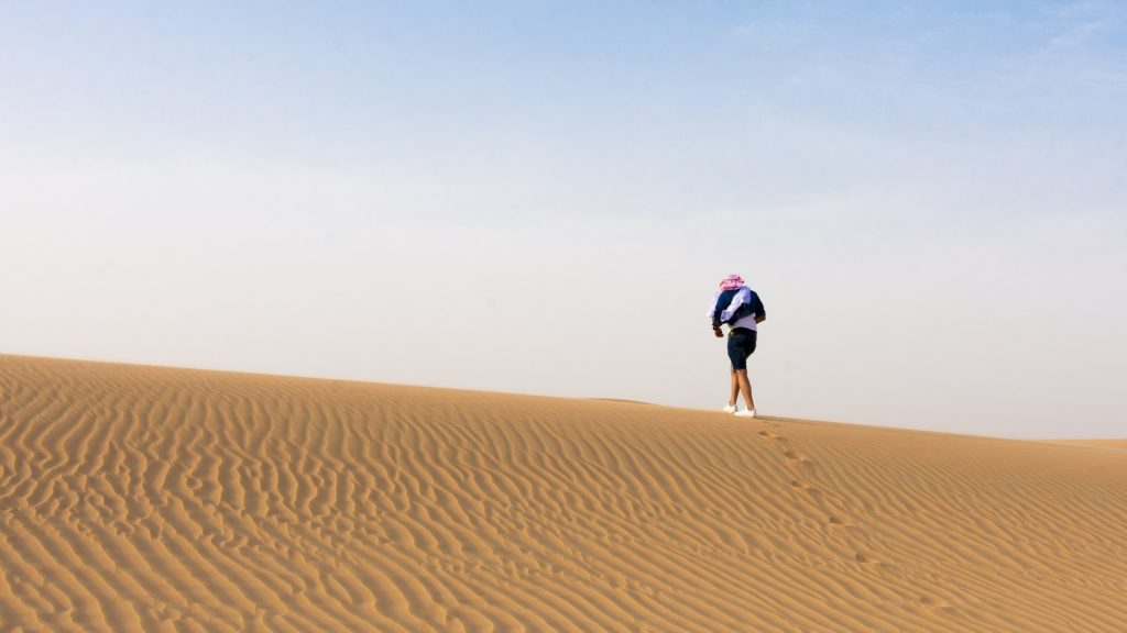 Férfi gyalogol a sivatagban