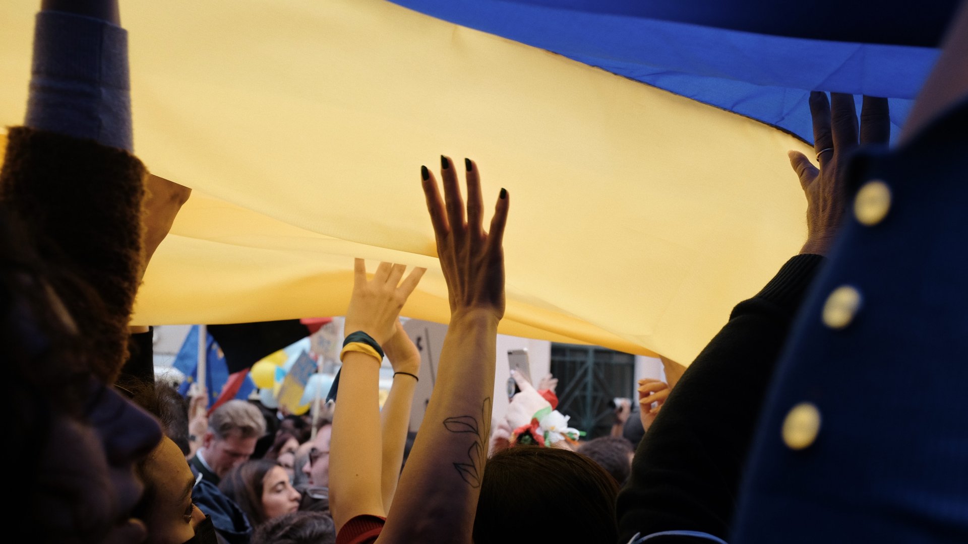 Ukrán zászló az emberek feje fölött a tömegben