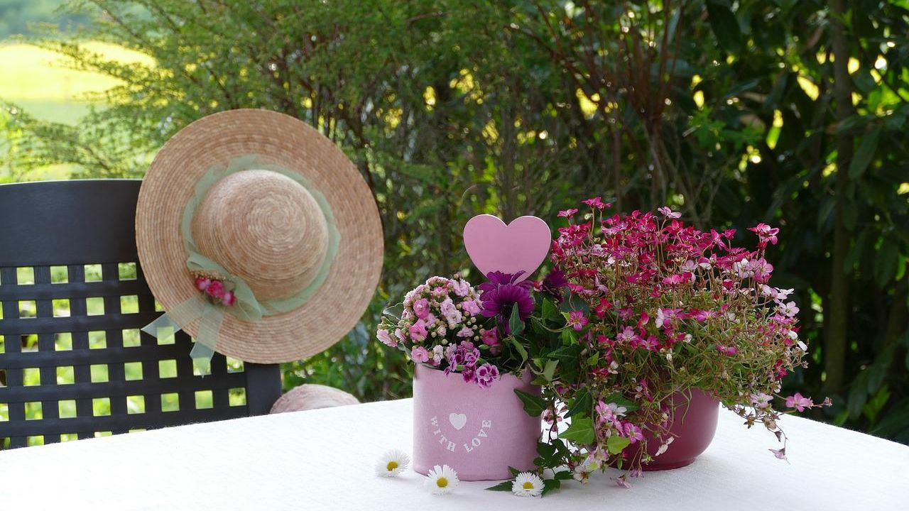 Asztali virág csendélet szívvel és szalmakalappal