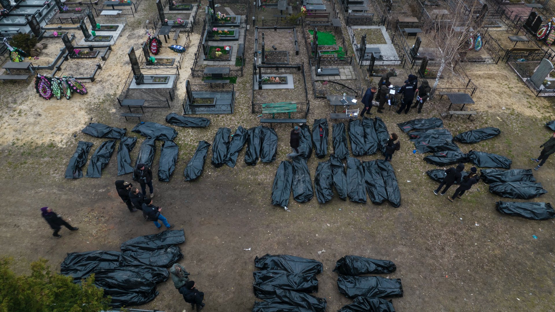 Civilek nejlonzsákban lévõ holttesteinek azonosítását végzik rendõrök és hatósági személyek a Kijev melletti Bucsában 2022. április 6-án