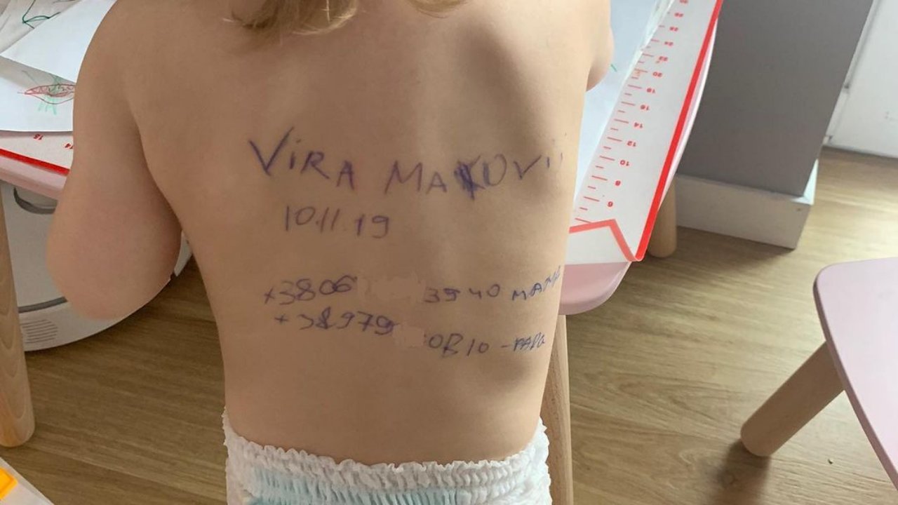 A család elérhetőségei egy ukrán kislány hátán, amelyet az édesanyja írt fel a háború miatt