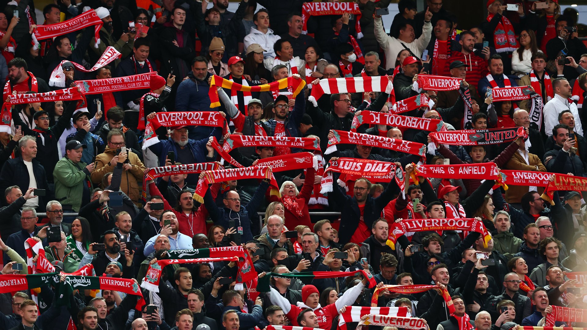 Liverpooli szurkolók sálat tartanak a fejük fölé a Liverpool és a Manchester United Premier League mérkőzés kezdőrúgása előtt az Anfielden 2022. április 19-én az angliai Liverpoolban
