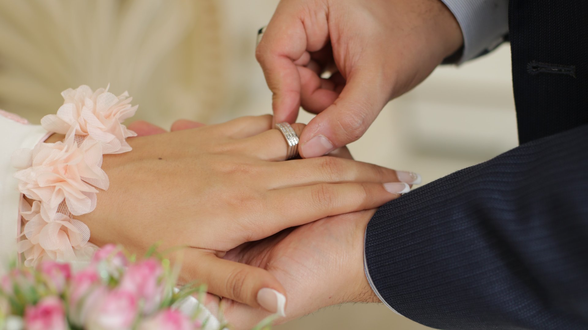 Karikagyűrűt húz a menyasszony ujjára a vőlegény az esküvőn