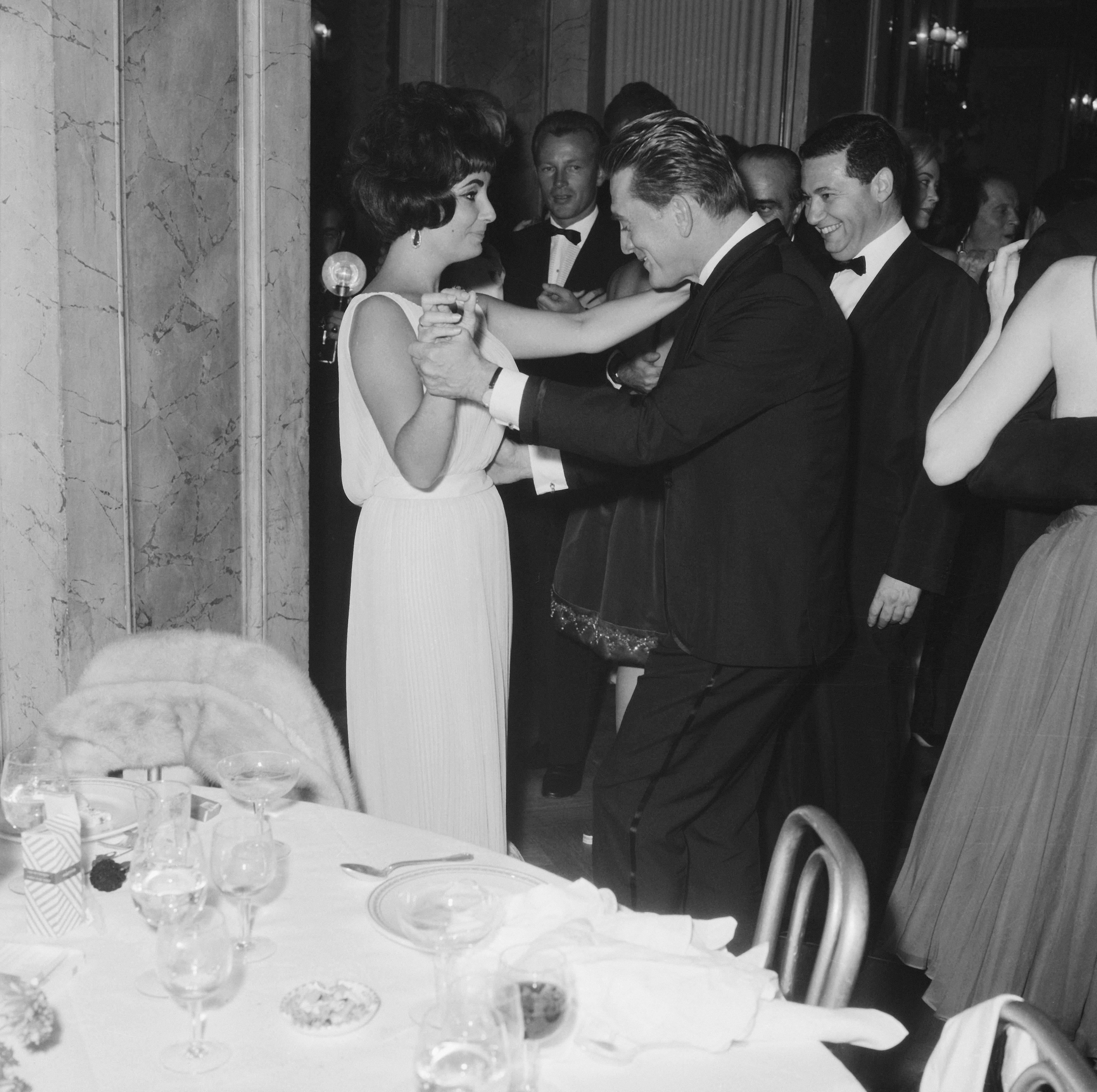 Elizabeth Taylor Kirk Douglas társaságában Rómában, abban a bizonyos fehér, Valentino estélyiben. 