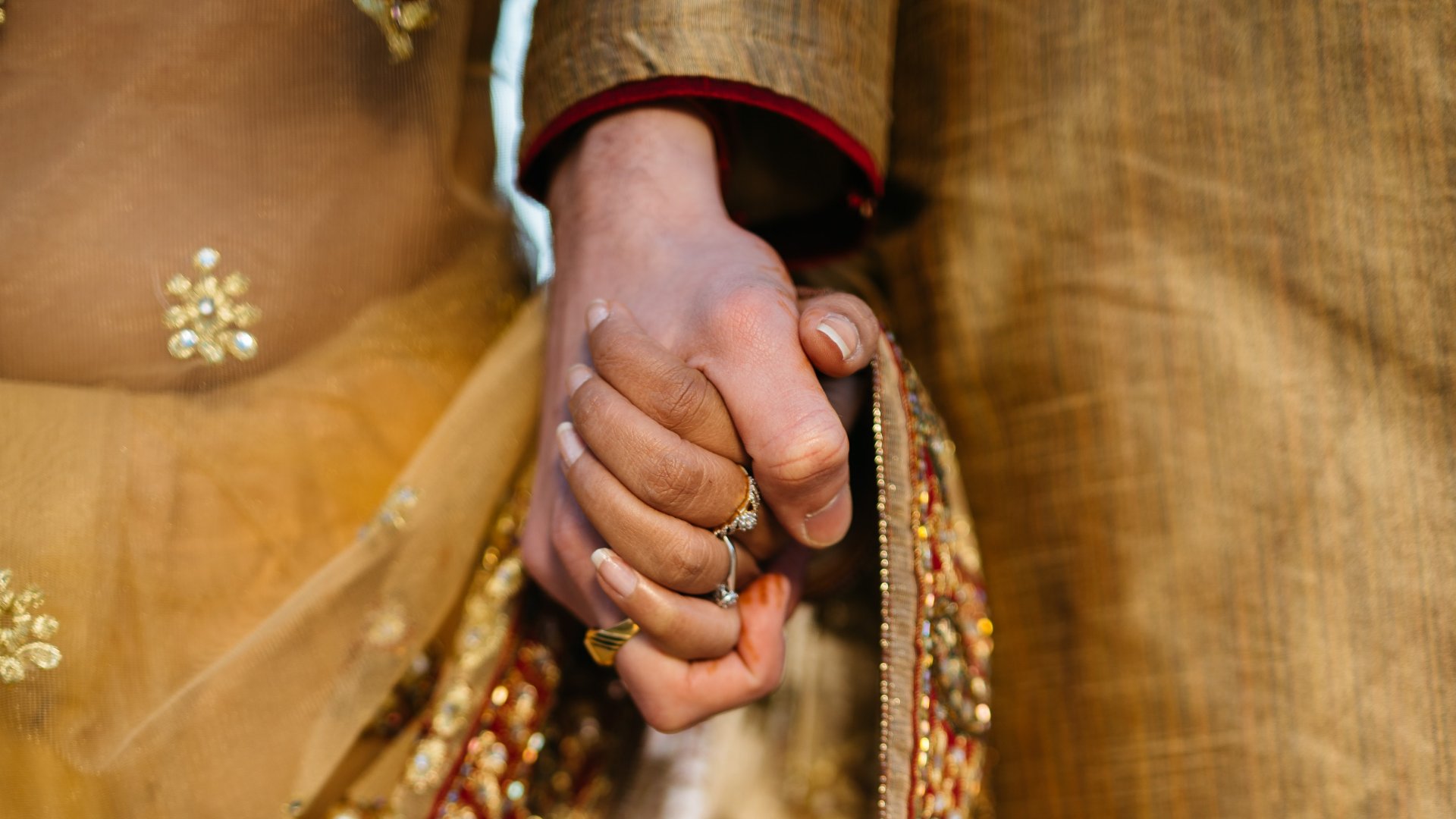Egy indiai pár megfogja egymás kezét az esküvőn