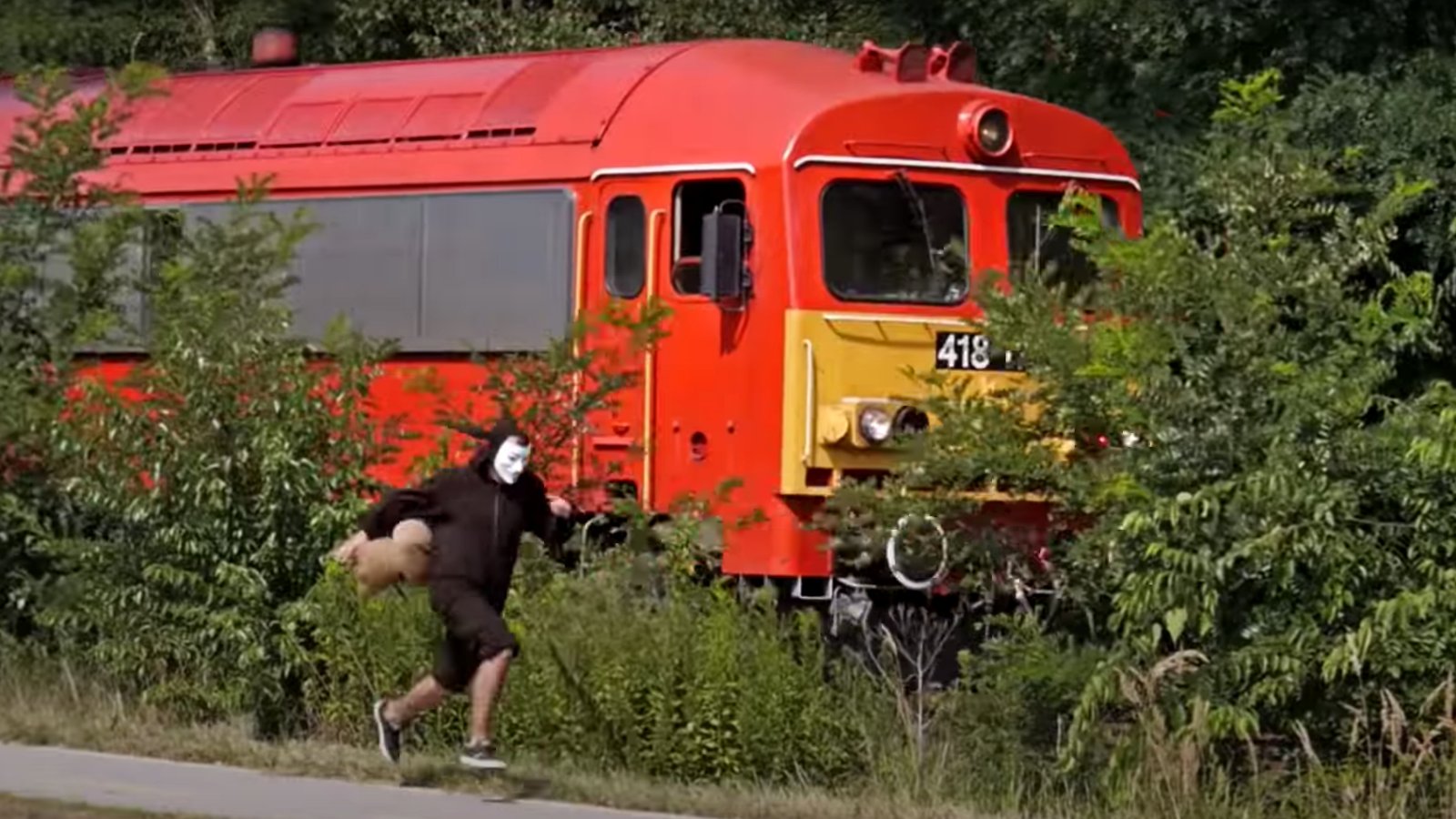 Csigajelmezes férfi futva előzi meg a vonatot a Mátészalka–Debrecen vasútvonalon