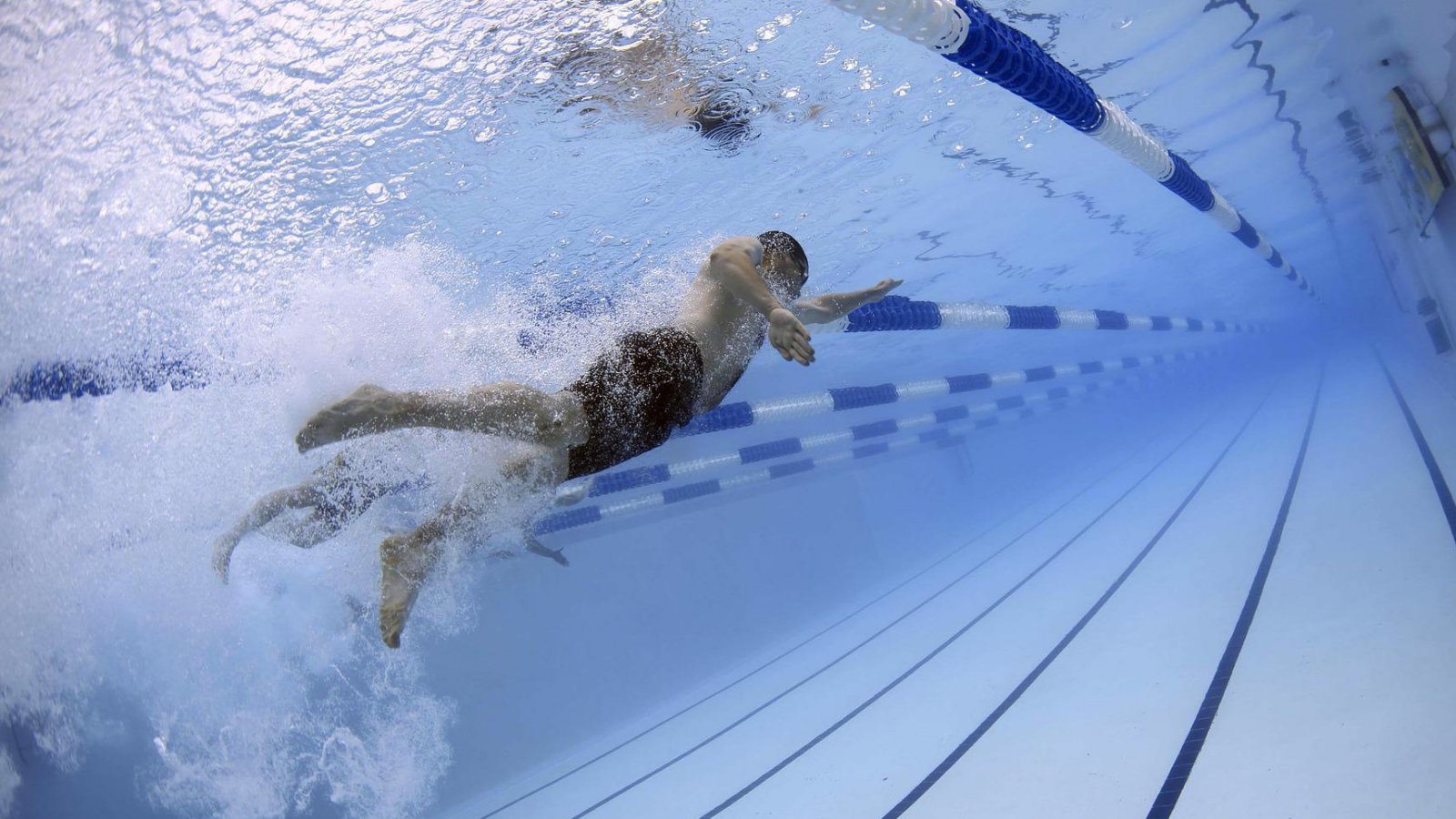 Víz alatti felvétel egy medencében úszó férfiről