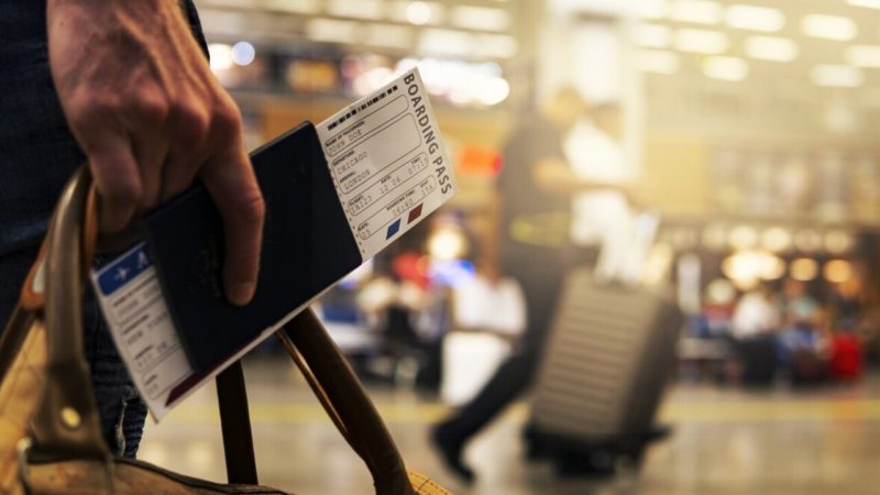 repülőtéren beszállókártyát tartó kéz
