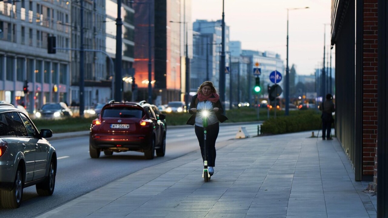 elektromos rollerrel a városban közlekedő nő
