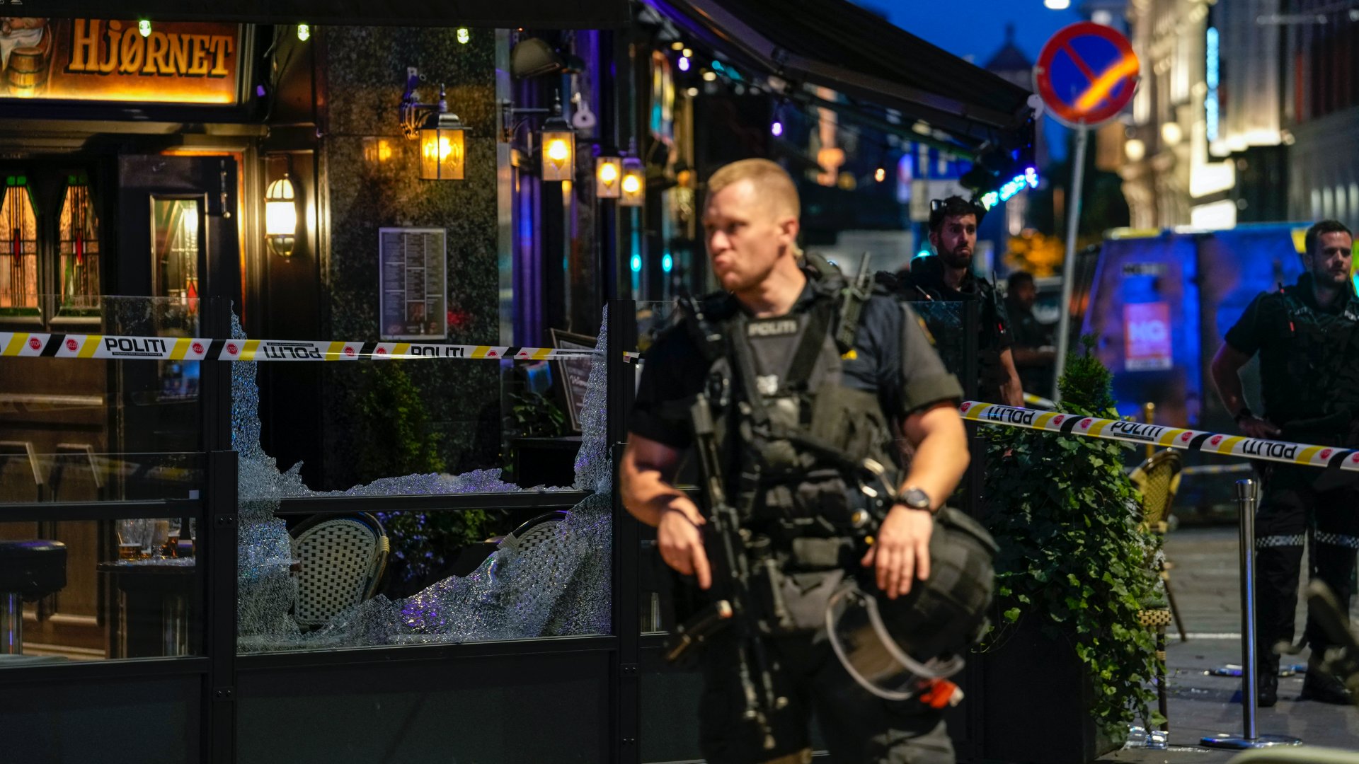 Egy norvég rendőr áll őrt Oslo belvárosában a biztonsági szalagok között 2022. június 25-én, miután lövések dördültek a London Pub nevű melegbárnál, és két ember meghalt