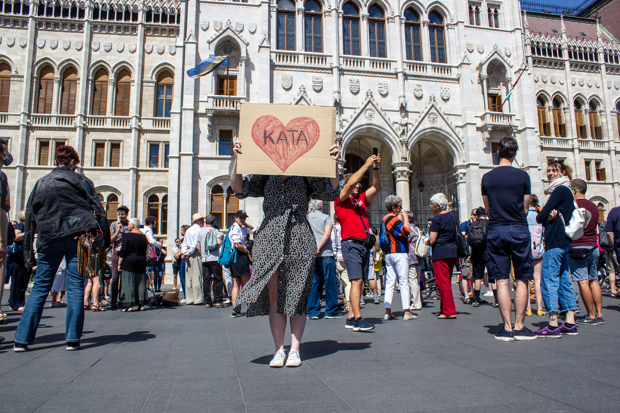 Piros szív rajzra írt KATA felirat egy transzparensen egy lány kezében a katatörvény módosítása elleni tüntetésen