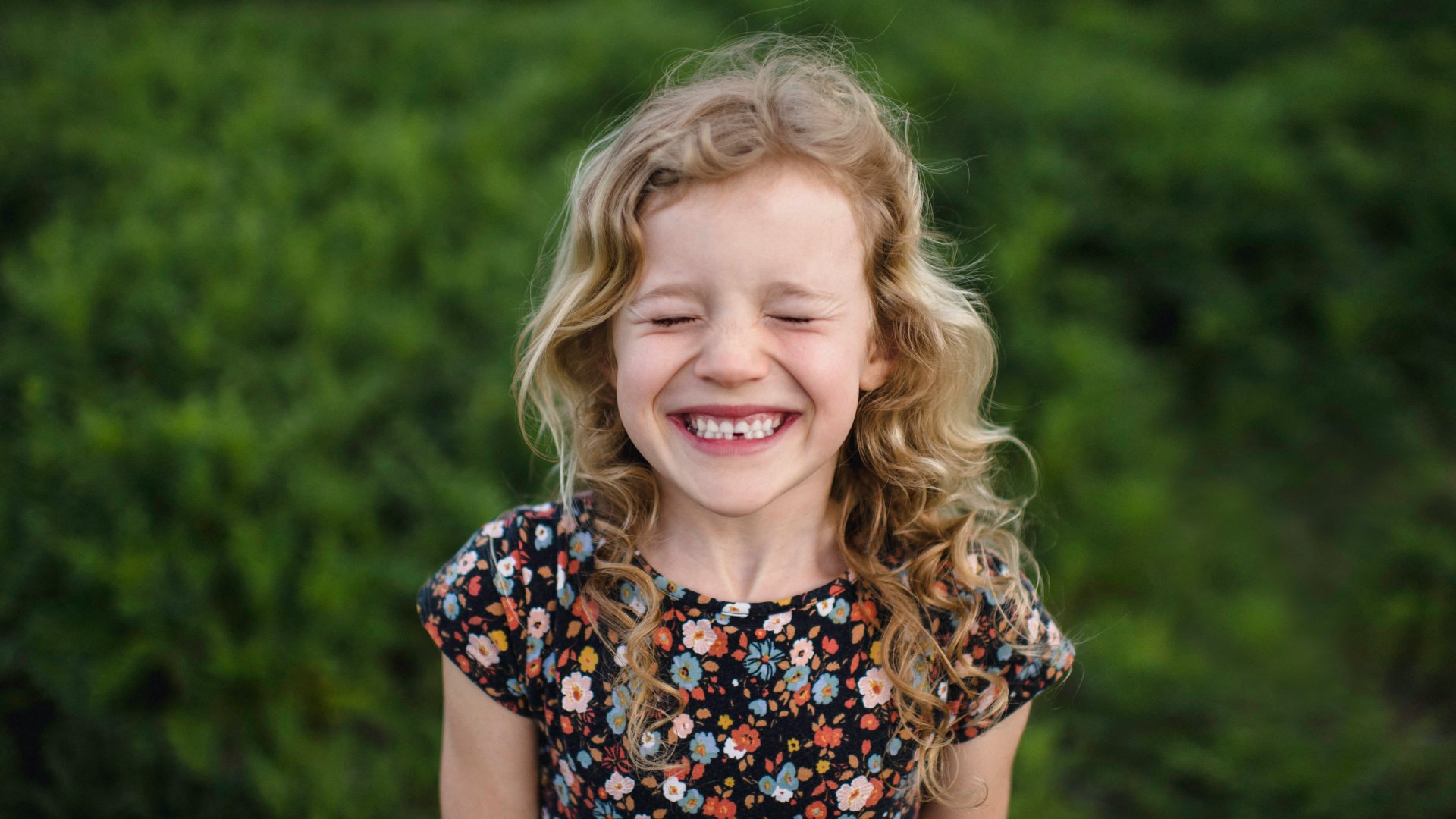 Egy kislány mosolyogva mutatja a kiesett tejfogát