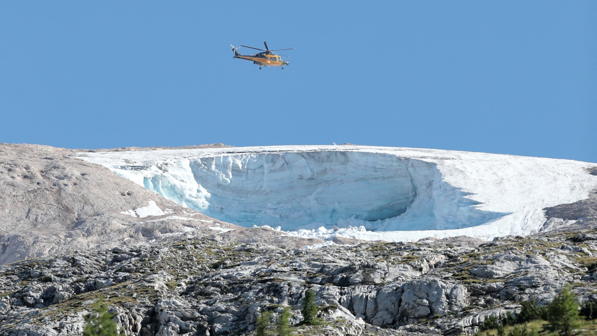 Helikopter repül az olaszországi Marmolada gleccser felett 2022. július 4-én, egy nappal azután, hogy egy jégomlás miatt hét ember meghalt