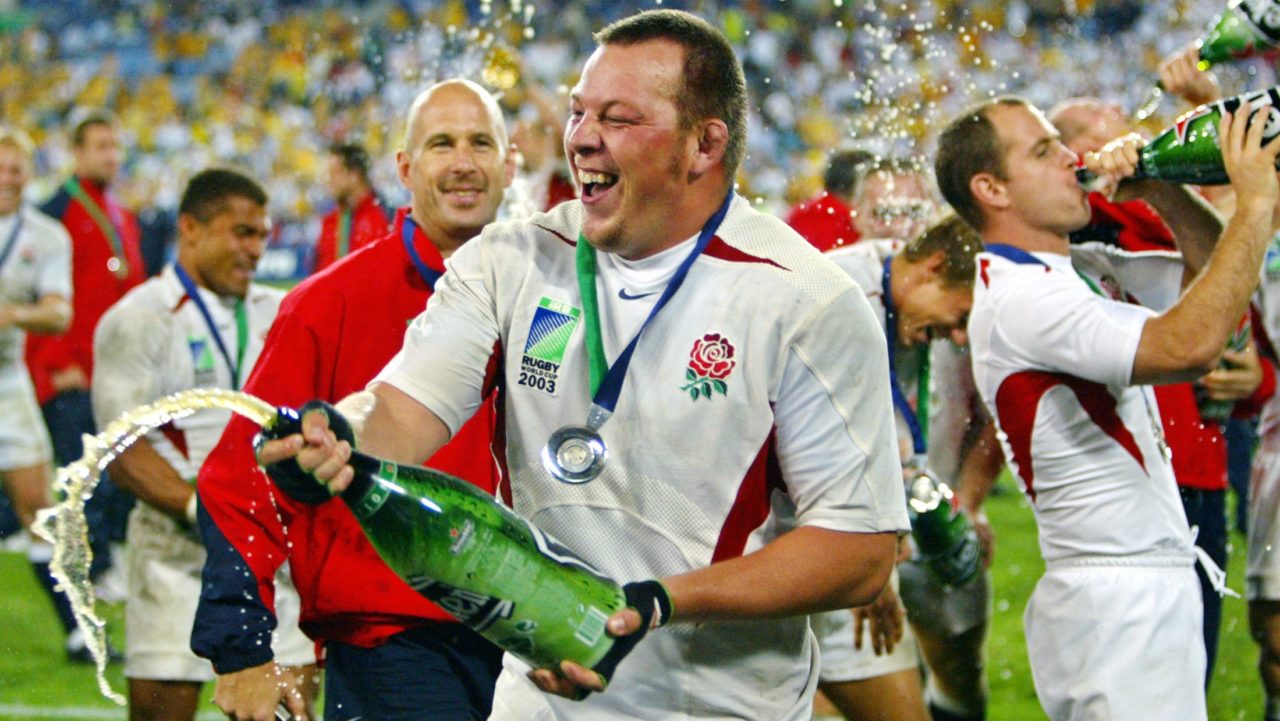 Steve Thompson 2003-ban a világbajnoki győzelmet ünnepli a pályán egy pezsgővel.