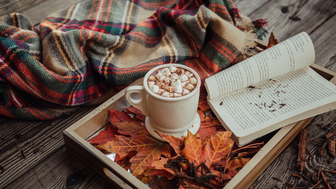 Kávé és könyv tálcán, őszi levelekkel