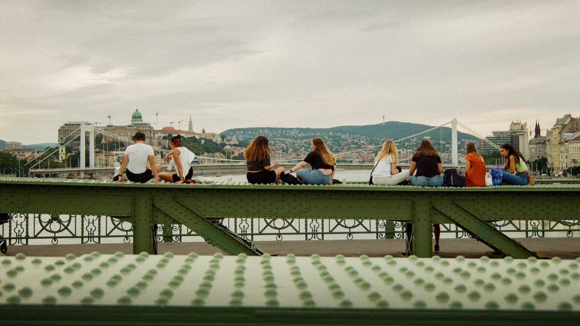 Fiatalok ülnek a budapesti Szabadság híd korlátján