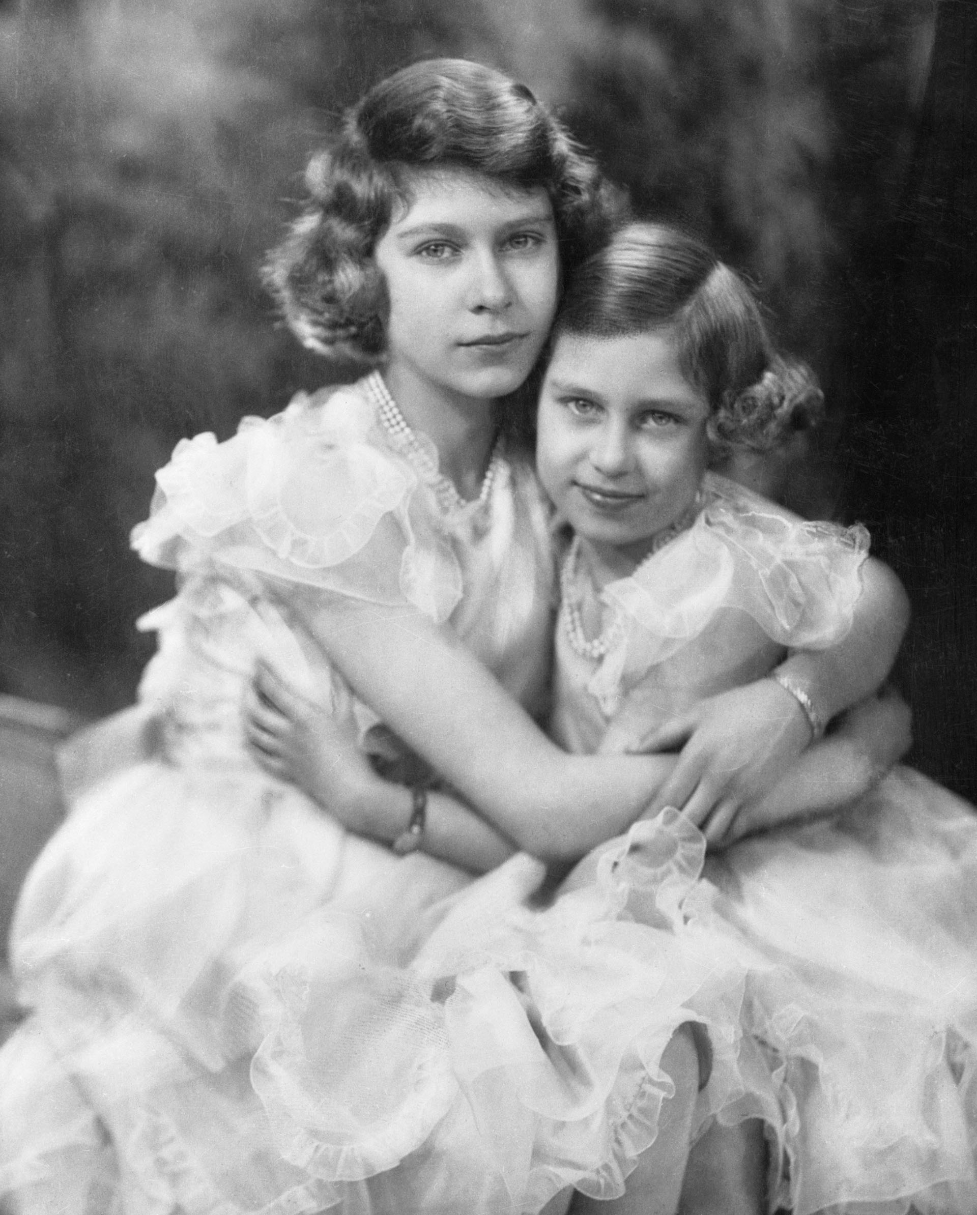 London, England: Latest Portrait Of Britain's Princesses--From war pressed England comes this charming photograph of her two best loved young ladies--the two young Princesses, daughters of King George VI. This portrait was made April 17th 1940, on the fourteenth birthday of Princess Elizabeth, who is heiress presumptive of the British Crown. Little Princess Margaret Rose is nine years old.
