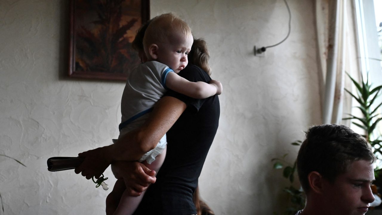 Zaporizzsja városban egy anya sétálgat a kisgyerekével egy lakásban.