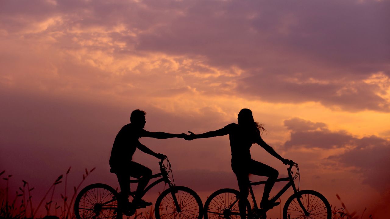 Férfi és nő kézenfogva kerékpáron